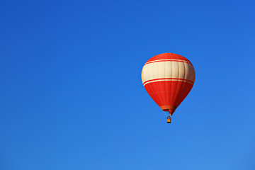 A red balloon floats on blue sky background in Vang Vieng, Laos