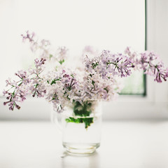 beautiful lilac flowers on the window in a vase, background - 350935161