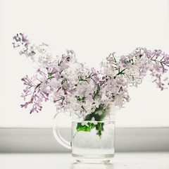 beautiful lilac flowers on the window in a vase, background - 350935324