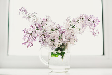 beautiful lilac flowers on the window in a vase, background - 350935394