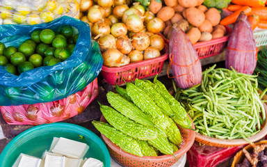 Asian street market selling bitter melon lime pea and onion reflex