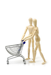 Shopping concept. Wooden doll and metal shopping cart.