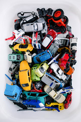 Pile of old toy mini cars thrown together in the storage container.