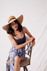 Thoughtful woman in straw hat sitting and relaxing