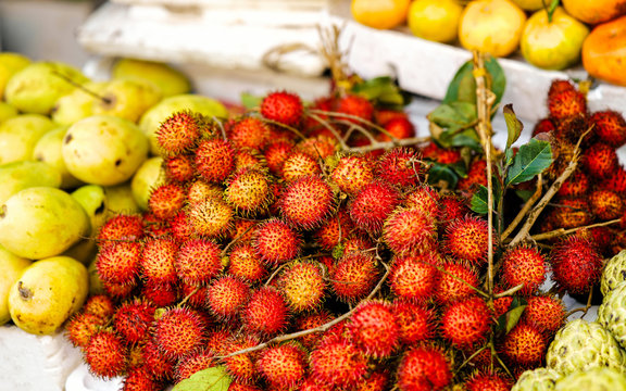 Asian street farmer market selling riped rambutan in Vietnam reflex