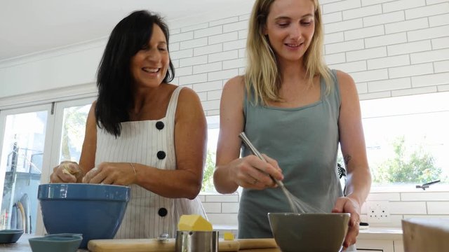 Mother and daughter baking together and catching up in the kitchen