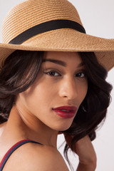 Lovely woman in a straw hat looking thoughtful