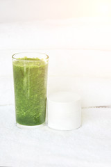 Green smoothie juice of vegetables and face cream in a white jar. The concept of cleansing the body of toxins. Organic energy eating. Athlete vitamic shake. Health lifestyle