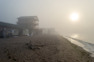 Coastal slum campsite in the fog