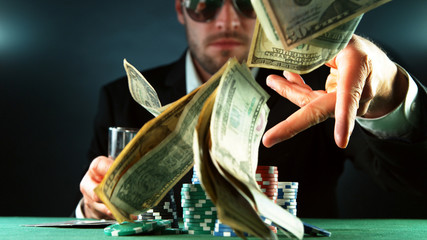 Poker player throwing US dollars
