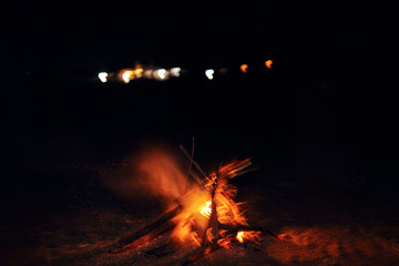 Abstract night sky with city lights and camp fire