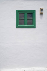 Fenêtre verte sur mur blanc et lampe murale