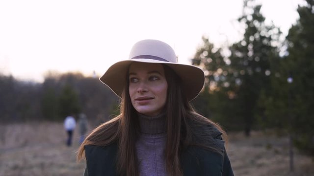 Portrait Smiling Woman in hat Stands in Woods in glamping. Concept Traveler Enjoys the Beauty of Nature. One 30s Person Standing in National Park Closeup