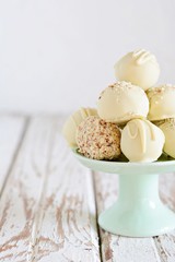 Chocolate truffle candies on white chocolate with nuts. Chocolate sweets on a light background, homemade sweets