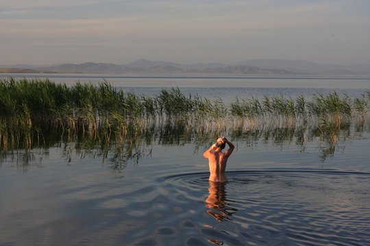 Woman washing hairs on the lake