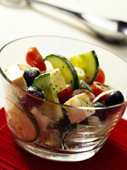 Greek Salad in Glass Bowl in table setting