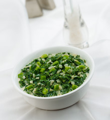 Onion and Pepper Spinach in white bowl on white clothbackground