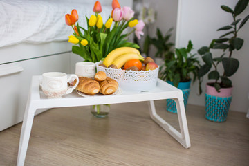 breakfast on a tray in a white bedroom