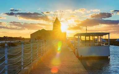 Sunset in Windmill in salt evoporation pond Marsala in Sicily reflex