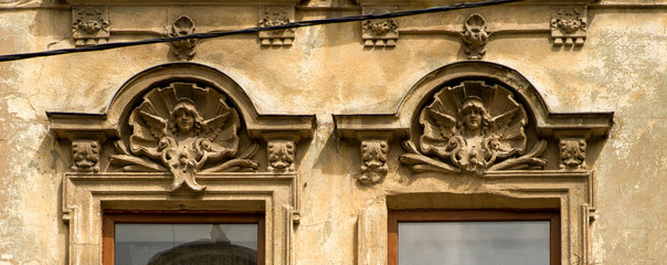 details of decorative ornament on plaster over the windows of an old building