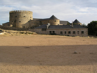 Spanish medieval fortress with earth floor in brown and ocher colors, with blue sky and nice...