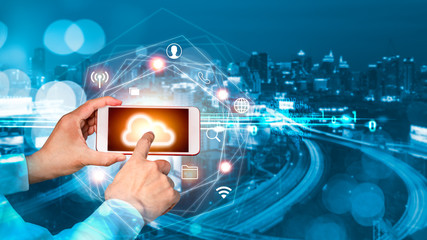 Businessman hand touch finger on smartphone screen with blurred city background. Digital connection at clouds services.