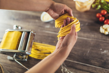 Closeup of process of making cooking homemade pasta. Woman make fresh italian traditional pasta.