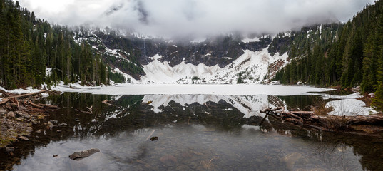 A snowbound lake shows reflections of snow covered mountains