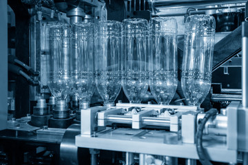 The PET bottle manufacturing processing. Operation of plastic drinking bottles after blowing...