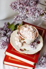 Cup of coffee with lilac petals, Cup of coffee near bouquet of spring flowers. Morning inspiration