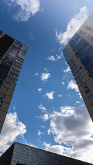Obraz premium Blue sky with white clouds betwen high buildings