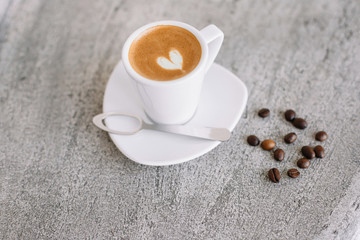 Obraz na płótnie Canvas Coffee in white cup, spoon, coffee beans