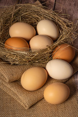Close-up of beige chicken eggs nest made of straw and jute fabric.