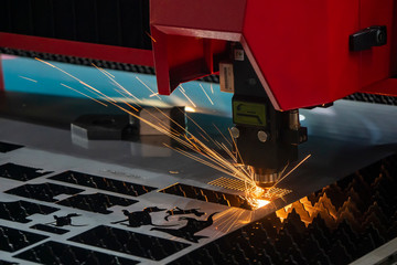 The  fiber laser cutting machine cutting the sheet metal  plate with the sparkling light.  The hi-technology sheet metal manufacturing process by laser cutting machine. - obrazy, fototapety, plakaty