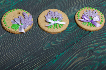 Gingerbread cookies decorated with glaze. On some ribbons tied to a bow. On brushed pine boards.
