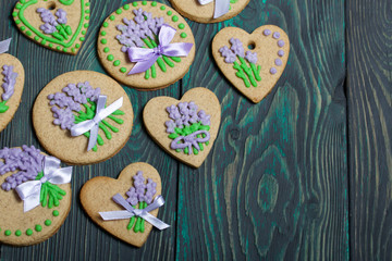 Gingerbread cookies decorated with glaze. On some ribbons tied to a bow. Gingerbread cookies are round and in the shape of a heart. On brushed pine boards.