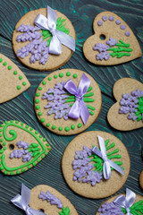 Gingerbread cookies decorated with glaze. On some ribbons tied to a bow. Gingerbread cookies are round and in the shape of a heart. On brushed pine boards.