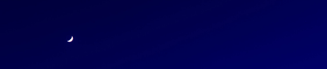 Obraz premium young moon on blue night sky long exposure nature scenic view panoramic picture with empty copy space for your text