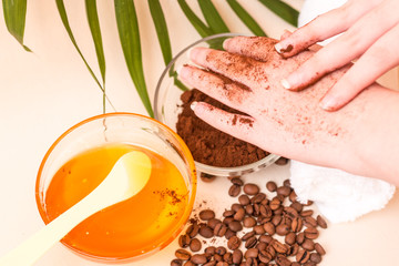 Spa care at home. Women's hands make a scrub with ground coffee. Scrub of coffee and honey. Bright background. Space for text. Horizontal photo. The view from the top.