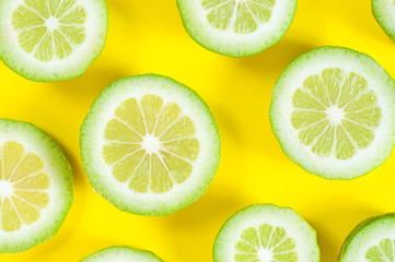 Green lime slices on yellow background
