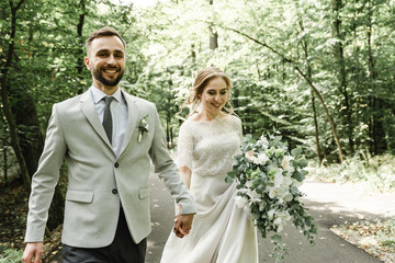 Just married couple dancing valse outdoors, free space. Bride and groom hug, blurred green grass...