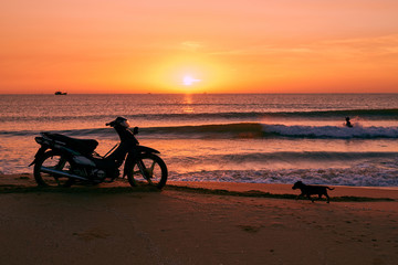 Fototapeta premium Biker on sunrise beach beautiful view