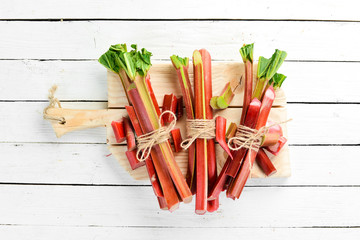 Fresh rhubarb on a white wooden background. Top view. Free copy space.
