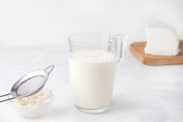 Fermented kefir drink in a glass and bacteria granules in a plate on a white background. Milk products.