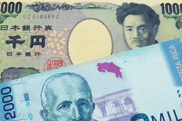 A macro image of a Japanese thousand yen note paired up with a colorful two thousand colones bank note from Costa Rica.  Shot close up in macro.