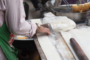 Cook preparing cake batter at a stall on the streets of Phnom Penh
