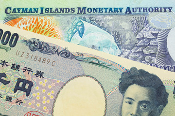 A macro image of a Japanese thousand yen note paired up with a colorful one dollar note from the Cayman Islands.  Shot close up in macro.