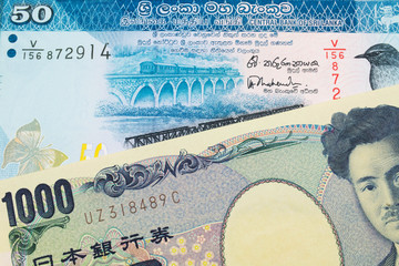 Fototapeta na wymiar A macro image of a Japanese thousand yen note paired up with a blue and white fifty rupee bank note from Sri Lanka. Shot close up in macro.