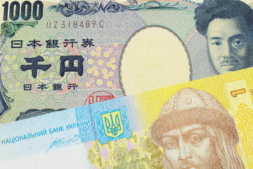 A macro image of a Japanese thousand yen note paired up with a blue, white and yellow one hyrvnia bank note from Ukraine.  Shot close up in macro.