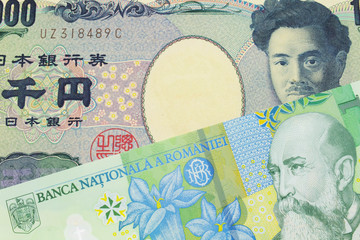 A macro image of a Japanese thousand yen note paired up with a green, plastic one leu bank note from Romania.  Shot close up in macro.